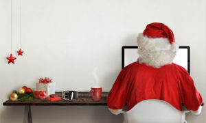 Santa Claus responds to letters on a computer for Christmas